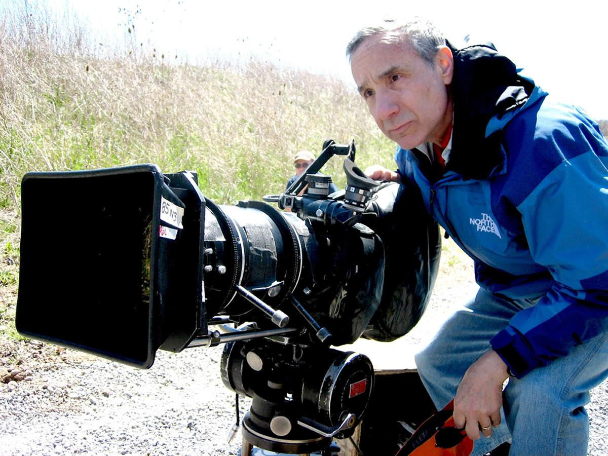 Lloyd Kaufman looking out of a camera and wearing a blue jacket.
