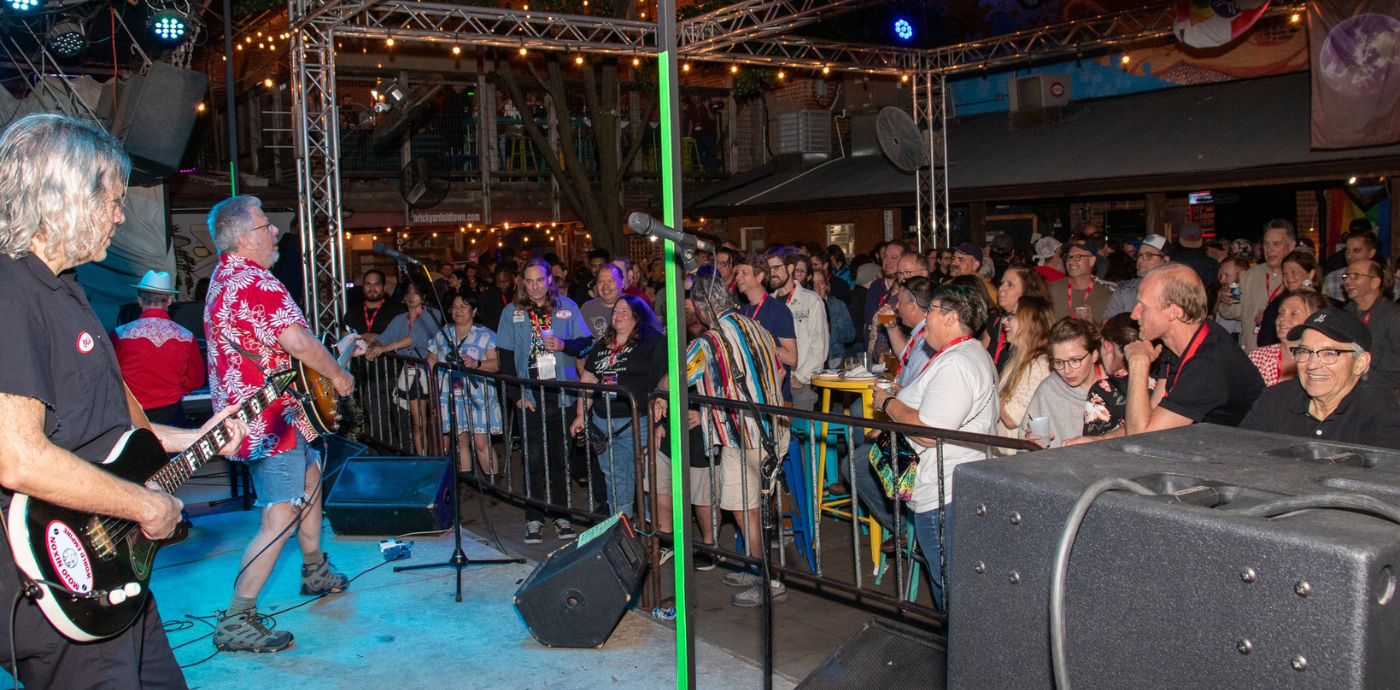 Mojo Nixon plays a set in front of a smiling crowd